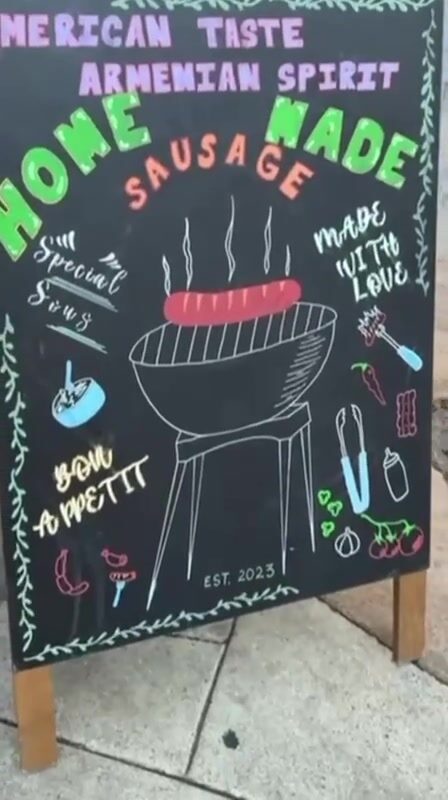 Chalkboard sign reading American Taste, Armenian Spirit, home made sausage, made with love, bon appetit